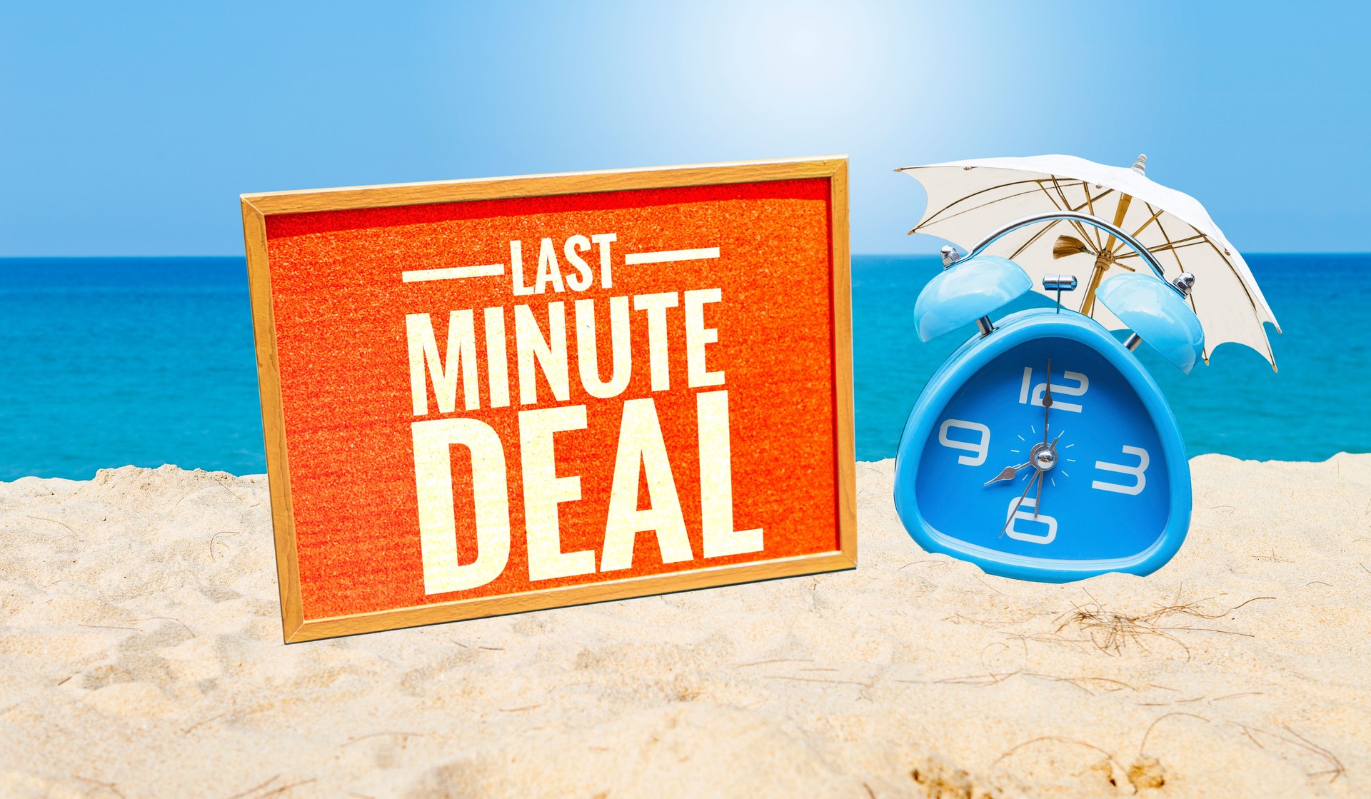 Last minute deal sign with blue alarm clock on tropical beach