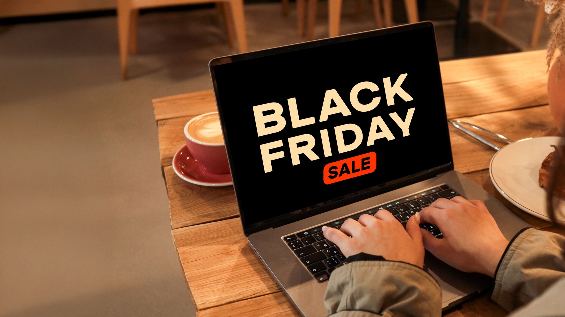 Black Friday sale on laptop in a cafe setting, online shopping concept