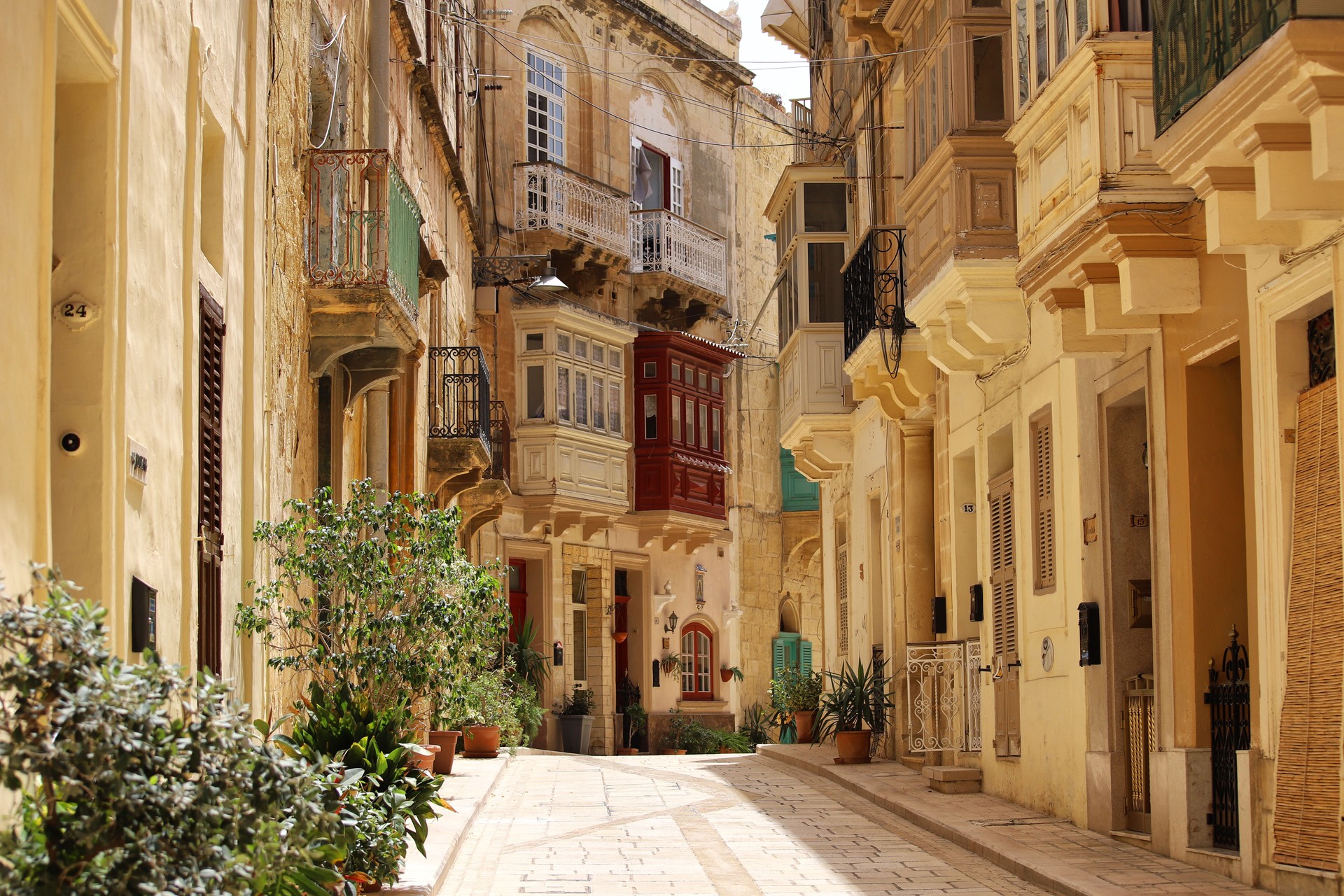 Traditional Maltese Street with Colorful Wooden Balconies and Limestone Houses in Valletta Traditional Maltese Street with Colorful Wooden Balconies and Limestone Houses in Valletta
