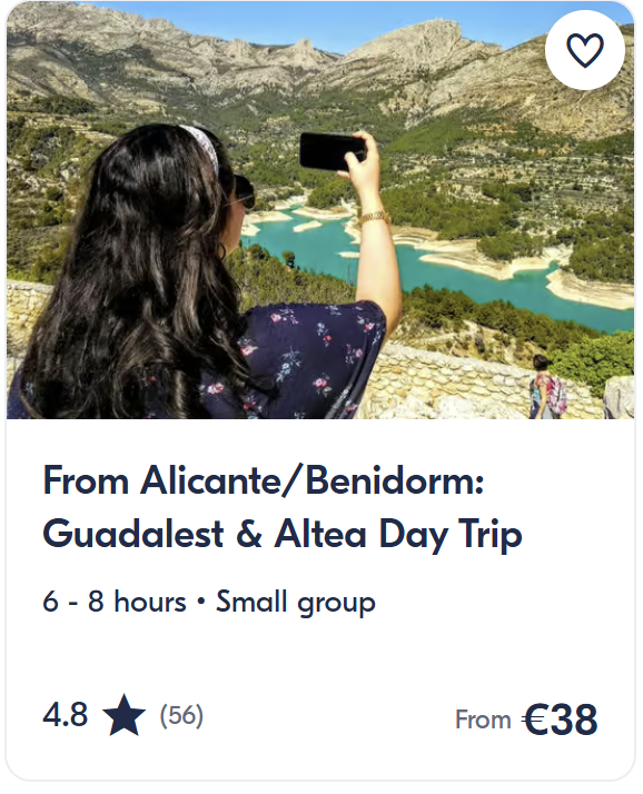 Woman taking photo of mountain lake and valley viewpoint near Guadalest, Costa Blanca – small group day trip from Alicante or Benidorm.
